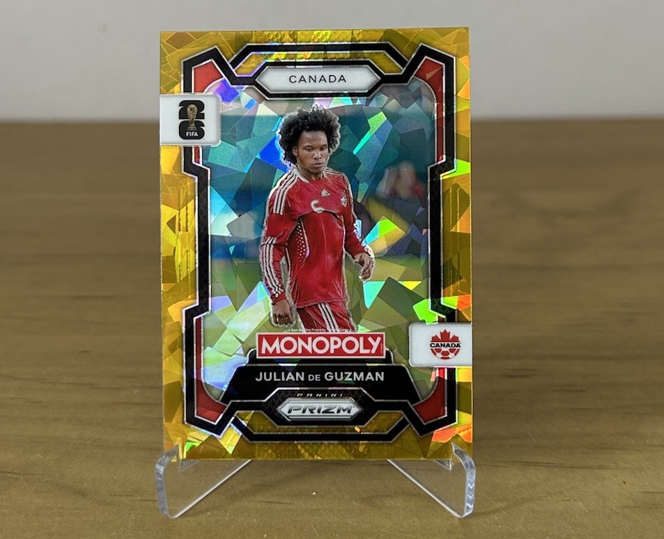 Carta Julian de Guzman Gold Cracked Ice Panini Prizm Monopoly FIFA World Cup 2026 Canadá